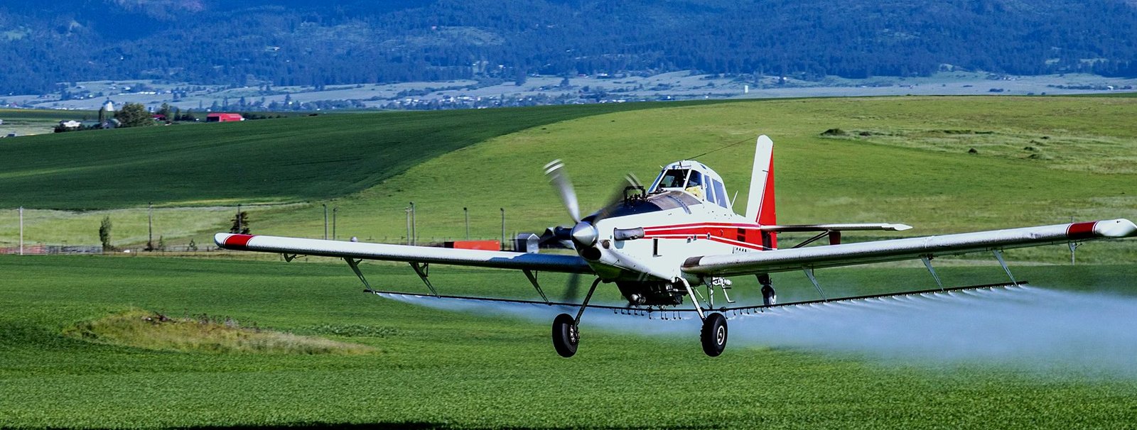Ag aircraft on a spray run over Northwest farmland